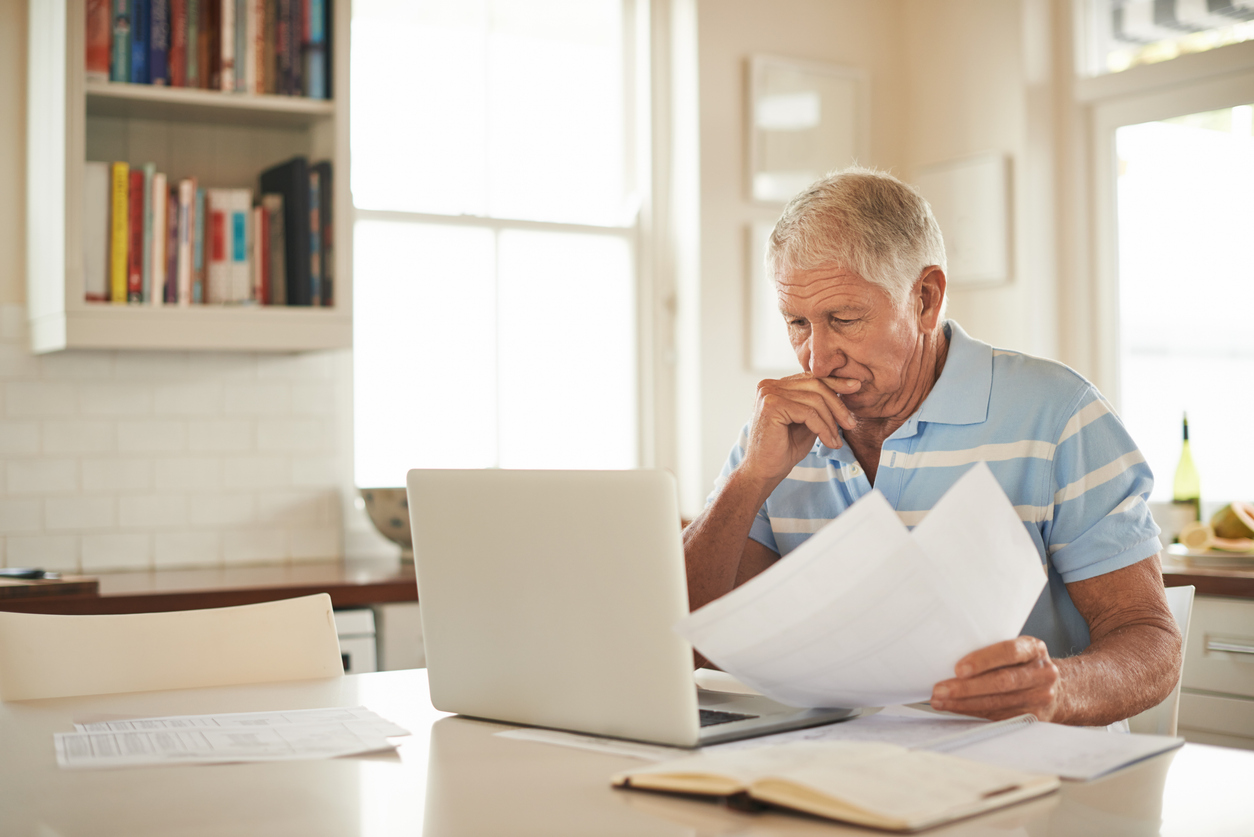 A senior sorting out documents for spousal survivor benefits after a divorce.